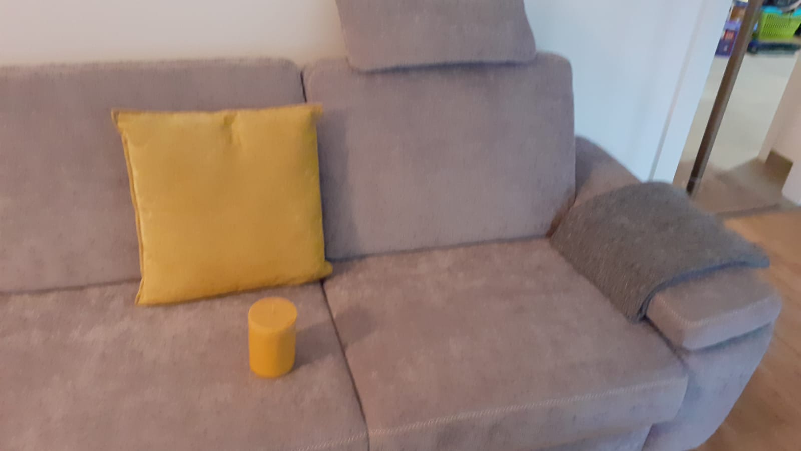 Stiltreu gelbes Kissen und Kerze auf Couch
